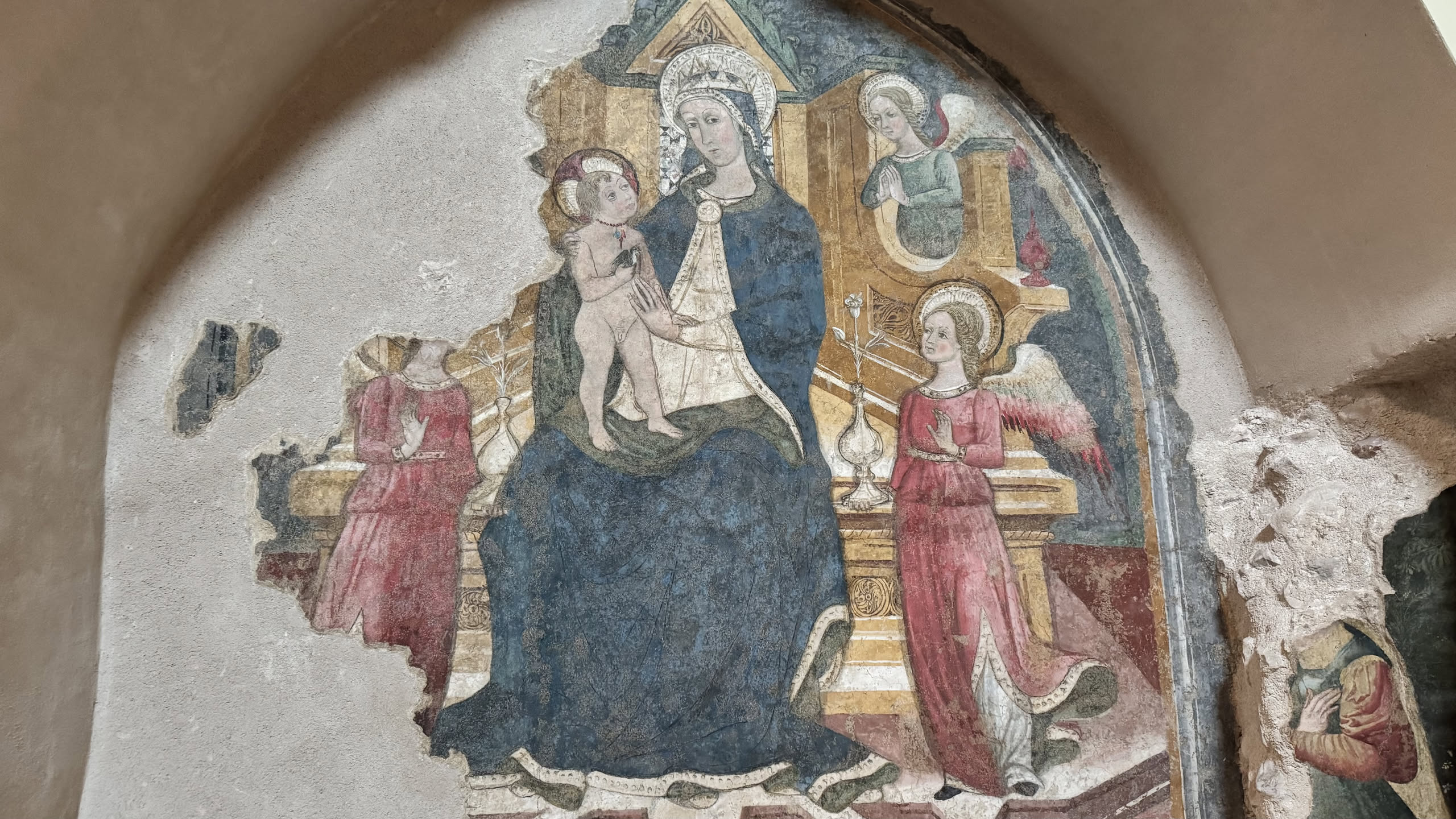 Affresco recuperato in una nicchia ad arco della basilica: Madonna in trono col Bambino tra angeli su fondo oro, con la data mccclxxvi in caratteri gotici in basso