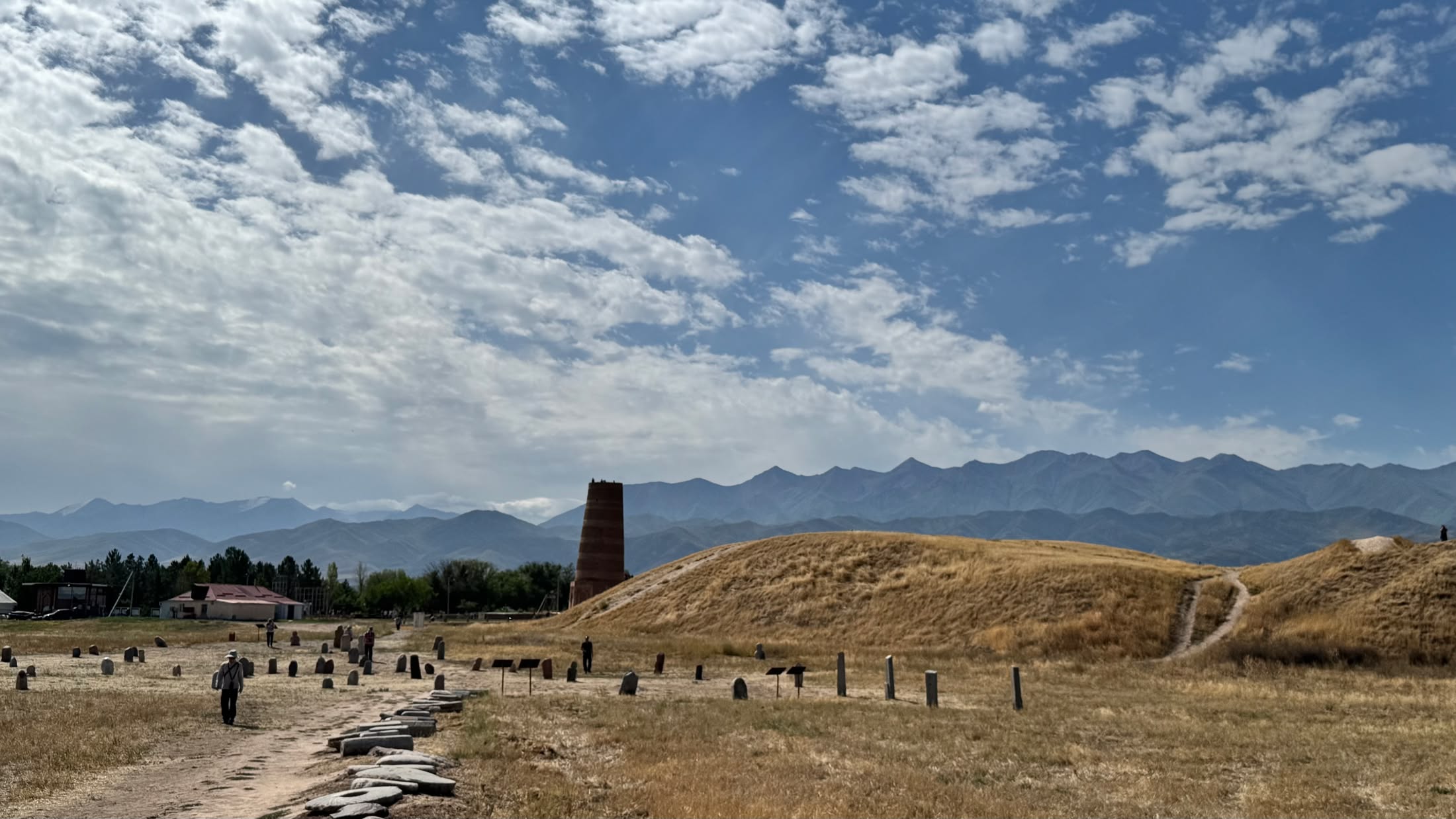 Il tumulo della cittadella di Balasagun con la torre di Burana sullo sfondo e le montagne oltre la piana