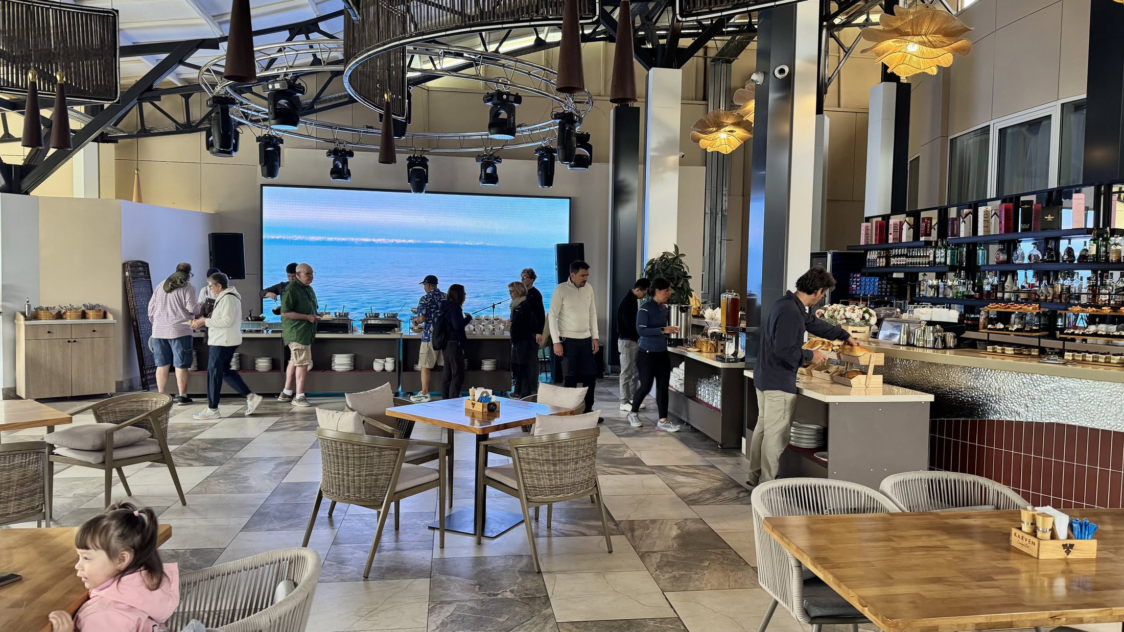 La lounge del resort, con il muro di led che trasmette l'immagine di un lago mentre il lago vero sta fuori dalla finestra