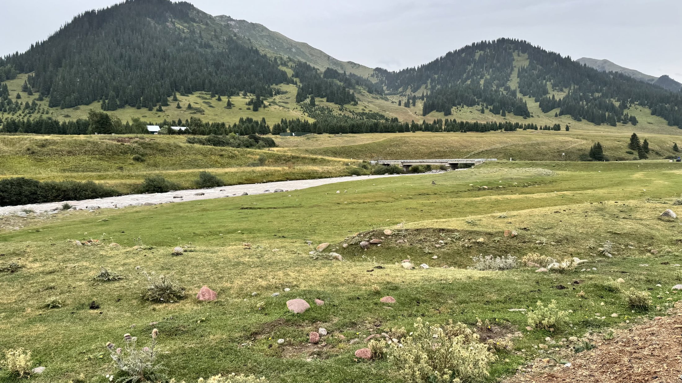 La valle di Karkyra aperta davanti a noi: prati gialli e verdi, il fiume che serpeggia e le montagne a strati