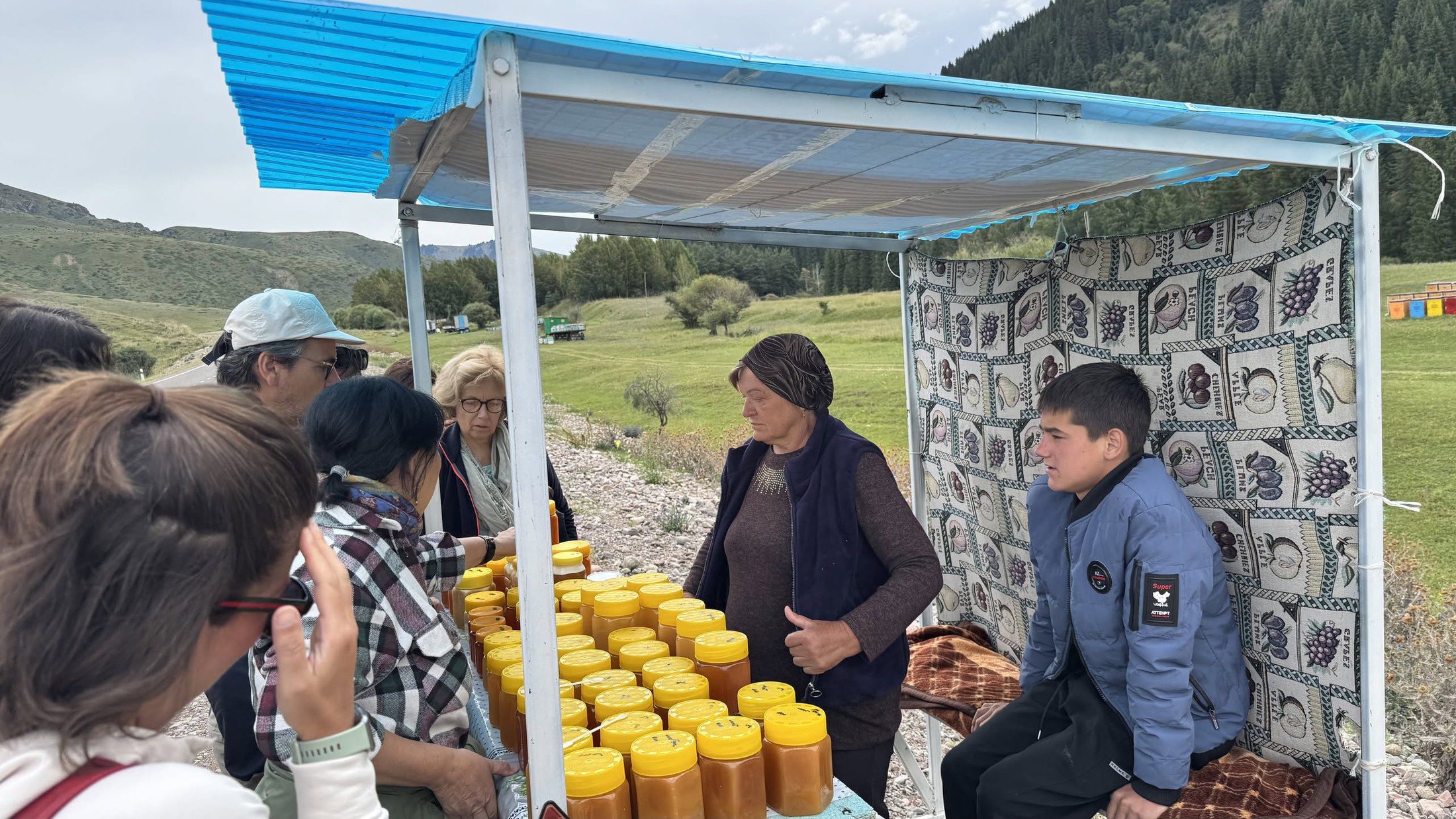 Sosta al banco del miele sul ciglio della strada, barattoli gialli in fila