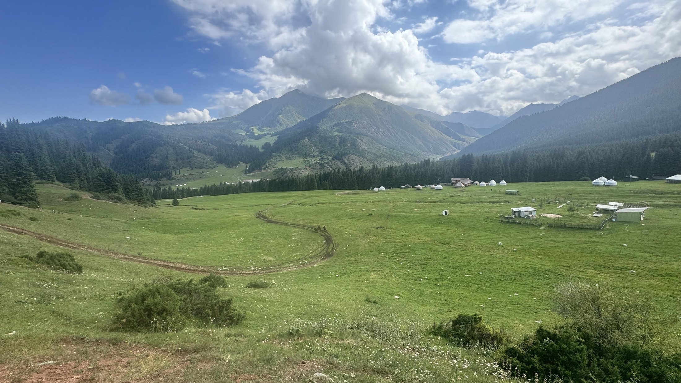 La valle si apre di colpo: prato, yurte bianche, e la salita ancora tutta lì.