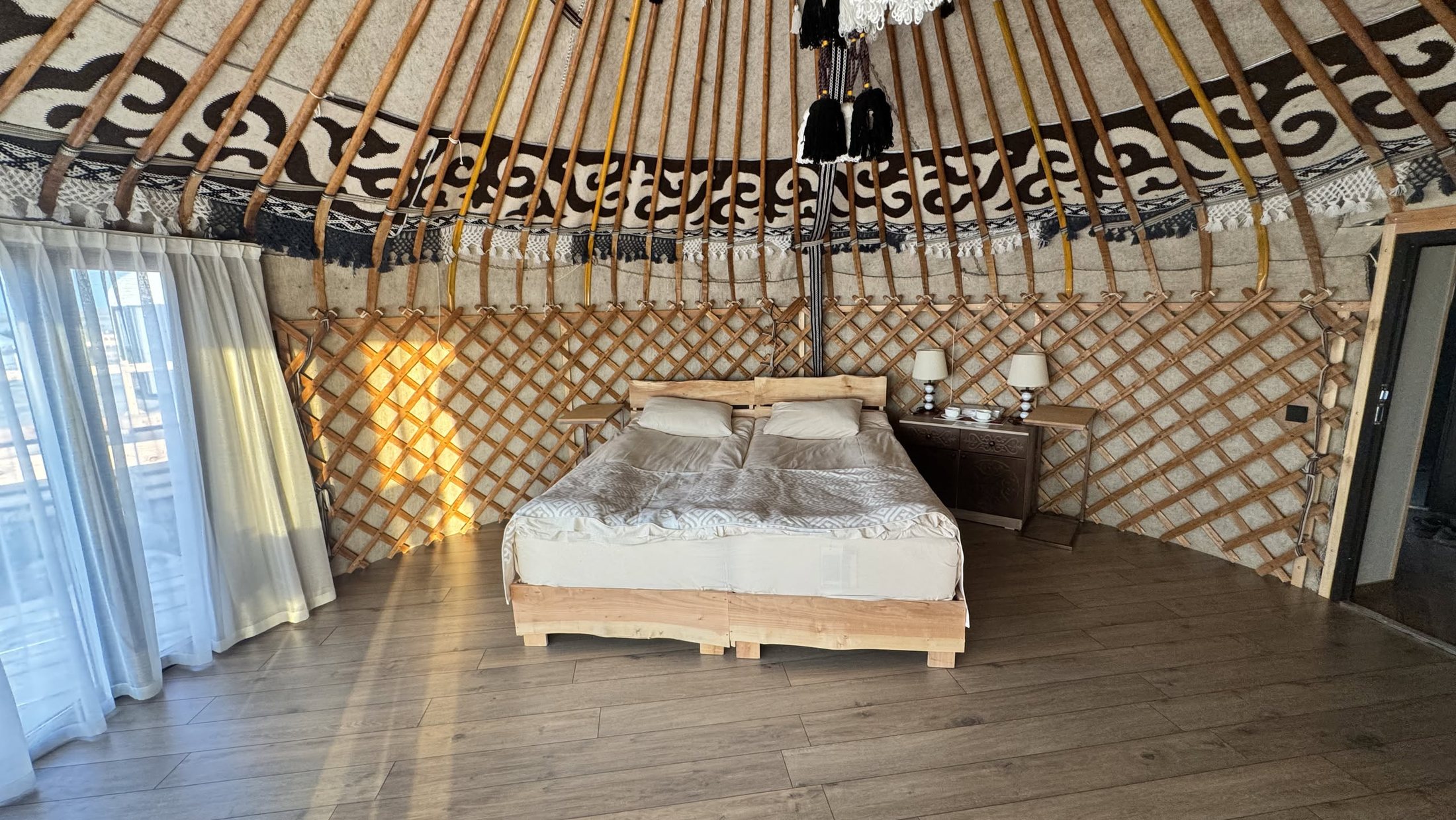 La yurta del campo: letto vero, tappeti, cupola di legno.