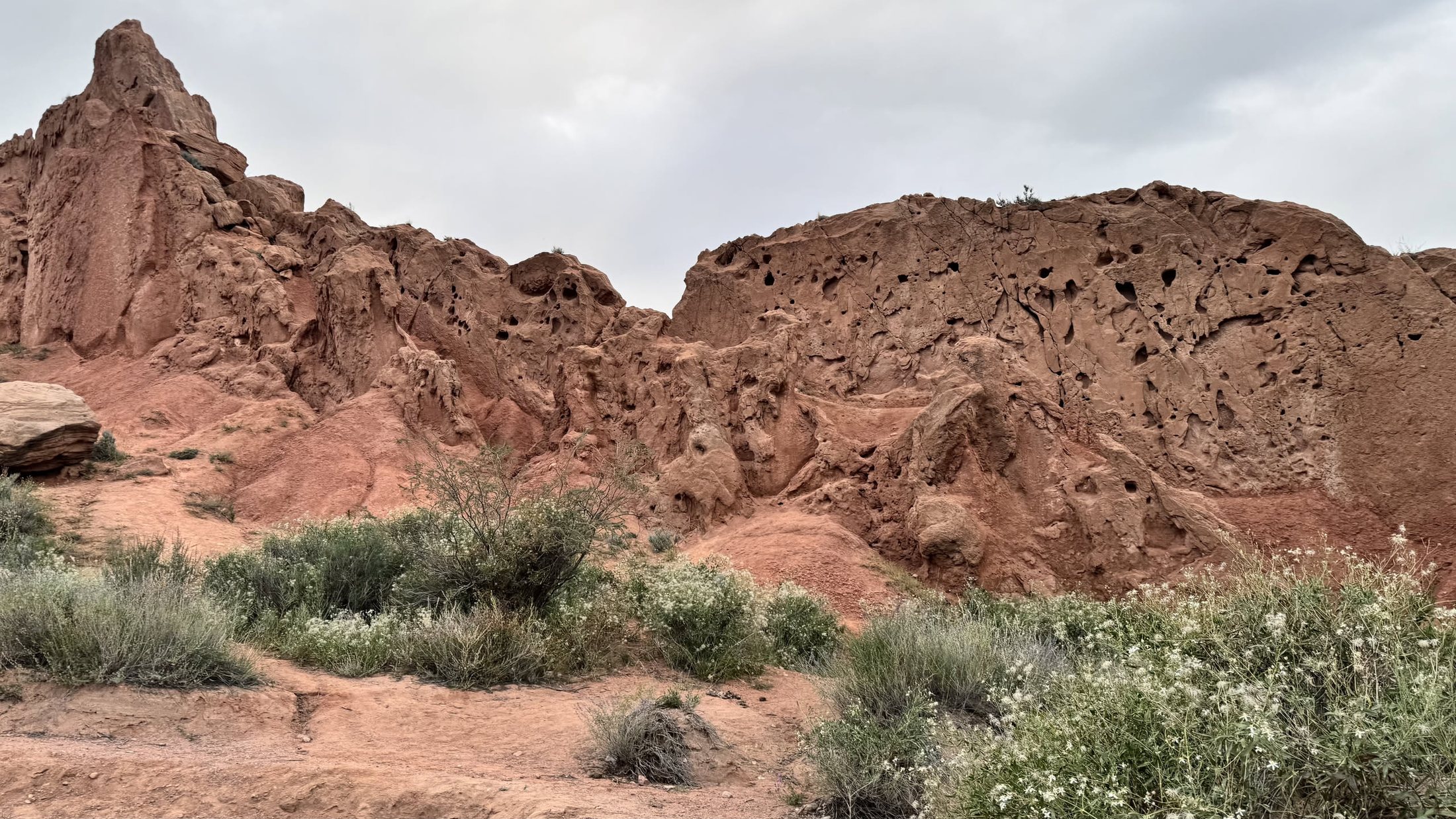 Il canyon Skazka: creste di argilla rossa che si perdono verso il lago.