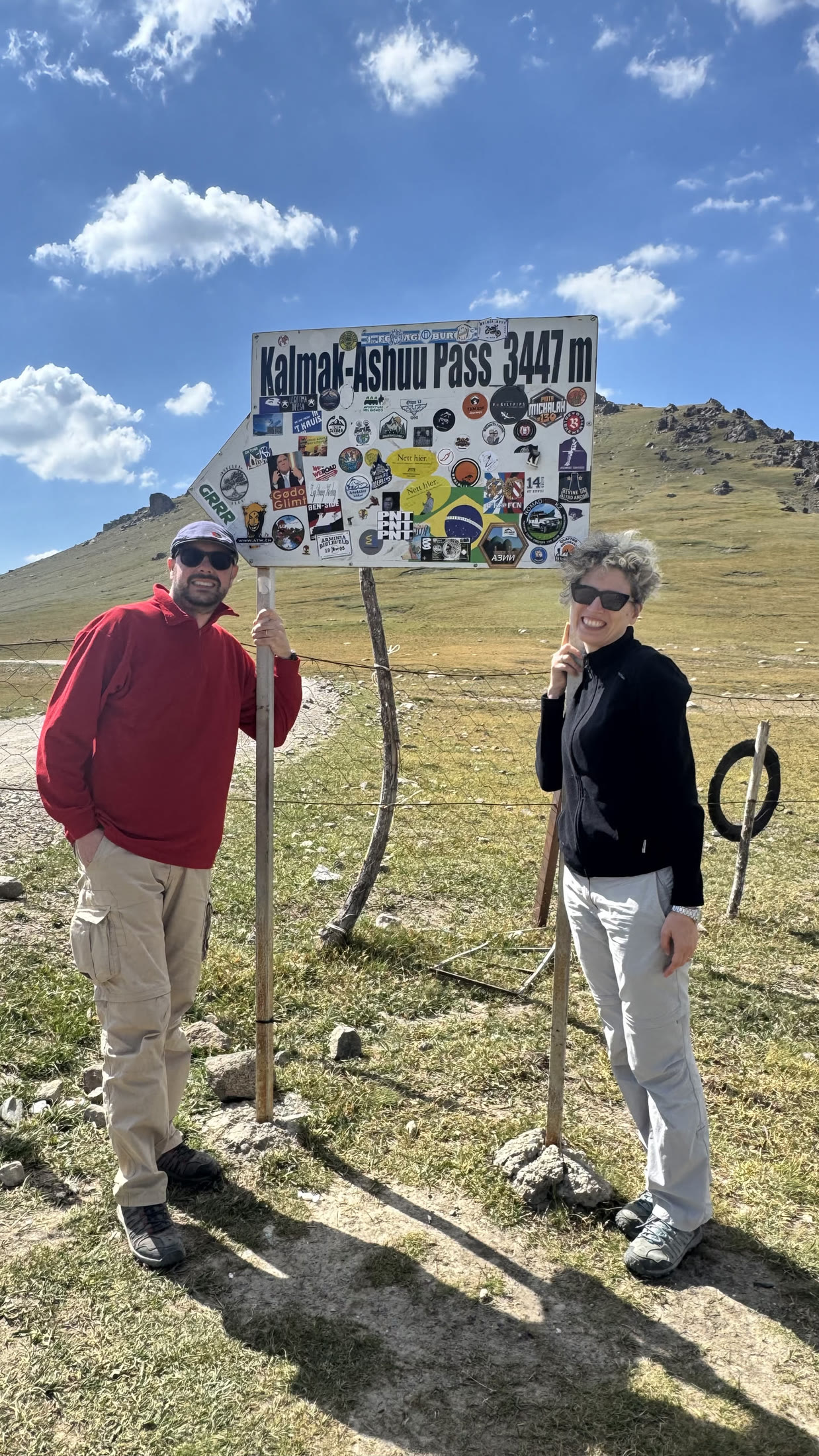 Passo Kalmak-Ashuu, 3447 m. Cartello con adesivi, vento incluso.