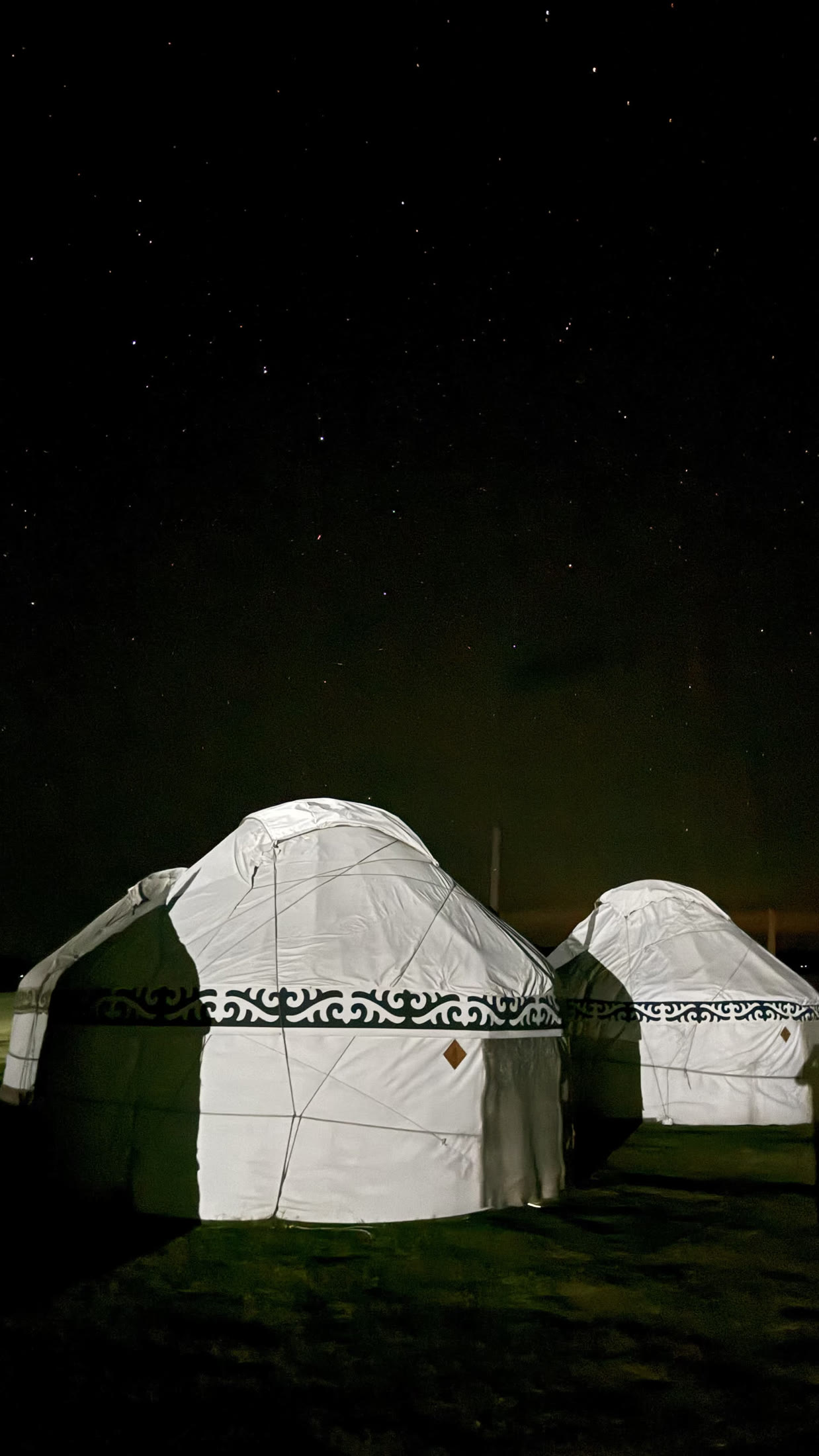 Le yurte accese sotto un cielo pieno di stelle.