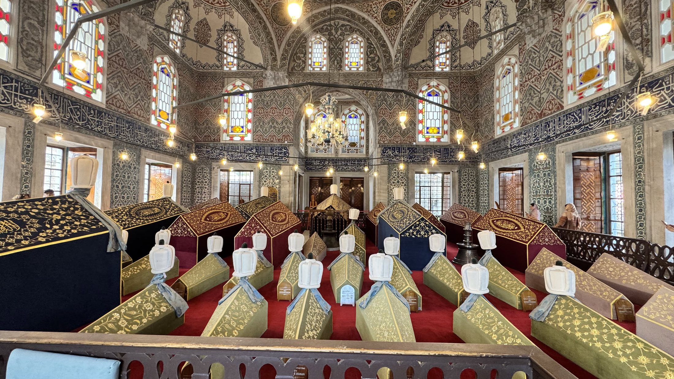 Türbe di Ahmet I: sarcofagi in fila, turbante di legno sopra ciascuno.