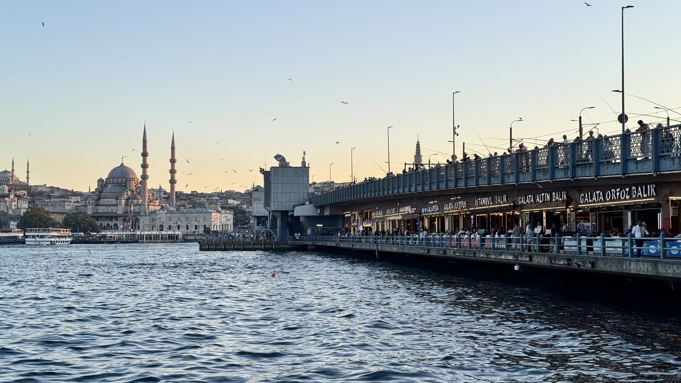 Il ponte di Galata al tramonto, con la Yeni Camii dietro e i pescatori sopra.
