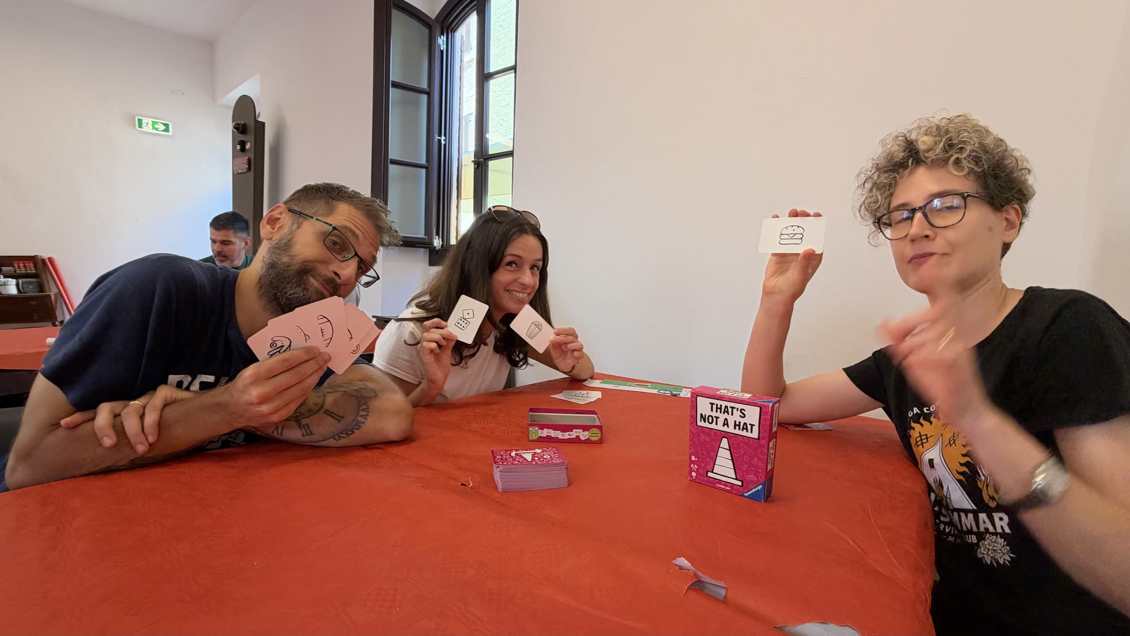 Carte alla mano e scatola sul tavolo: a metà partita si mostrano le penalità.