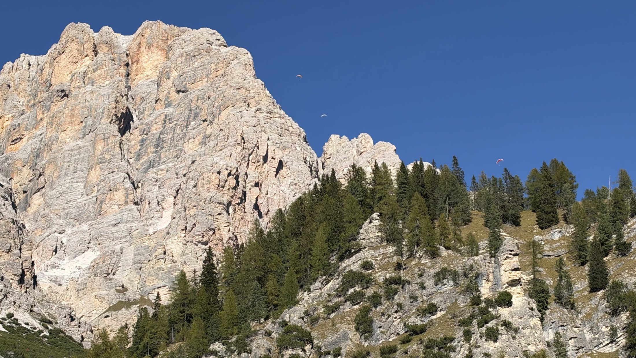 Dopo pranzo, a pancia all'aria: la parete, e lassù, minuscolo, un parapendio