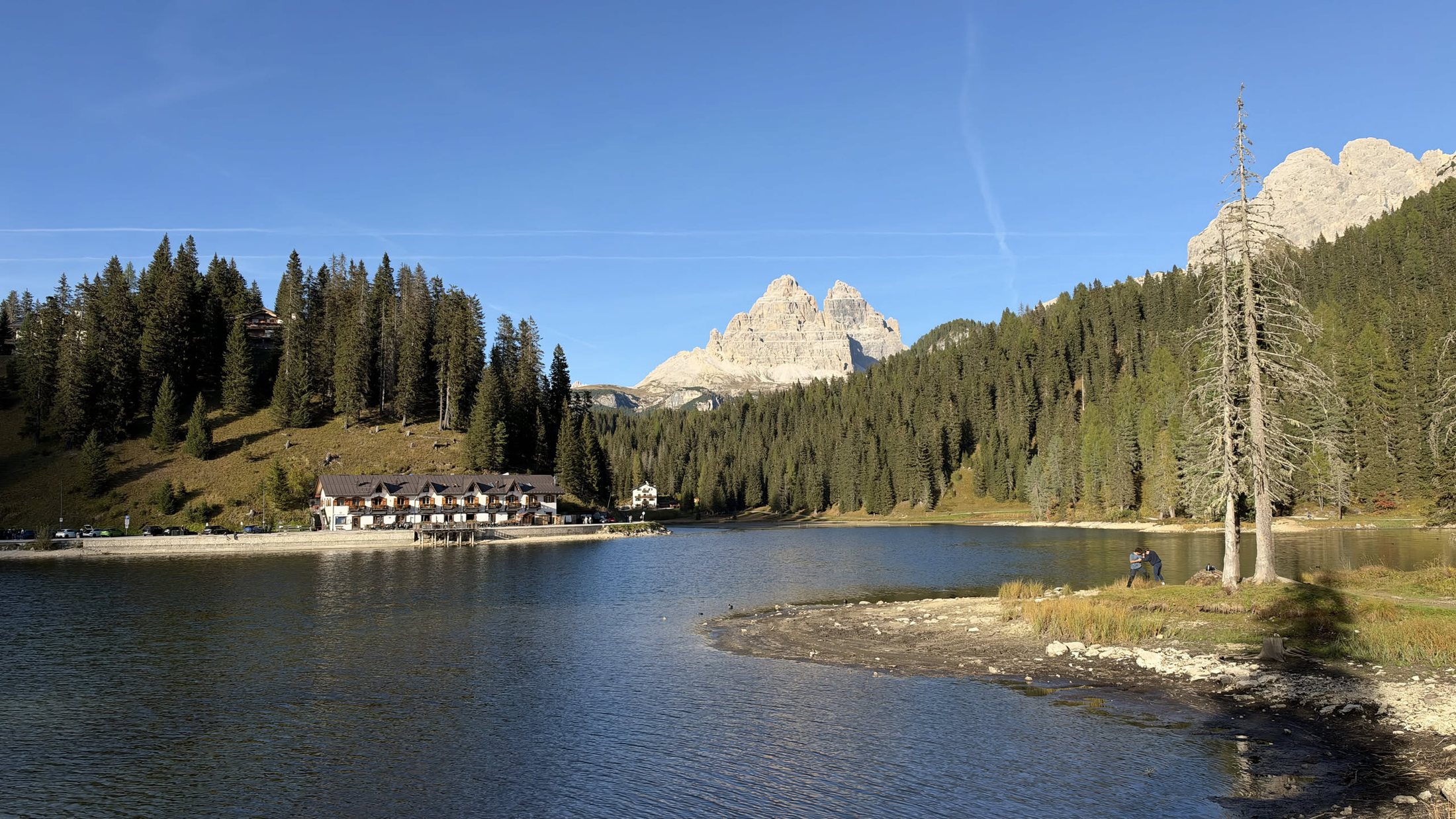 La sponda nord, con le Tre Cime che spuntano fra gli abeti