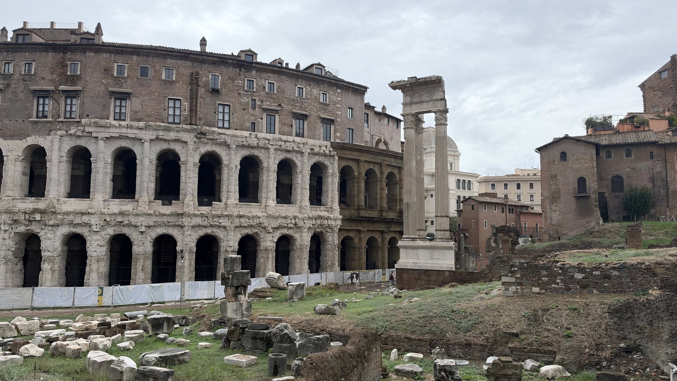 Il Teatro di Marcello, con il palazzo cresciuto sopra, e le tre colonne del tempio di Apollo Sosiano.