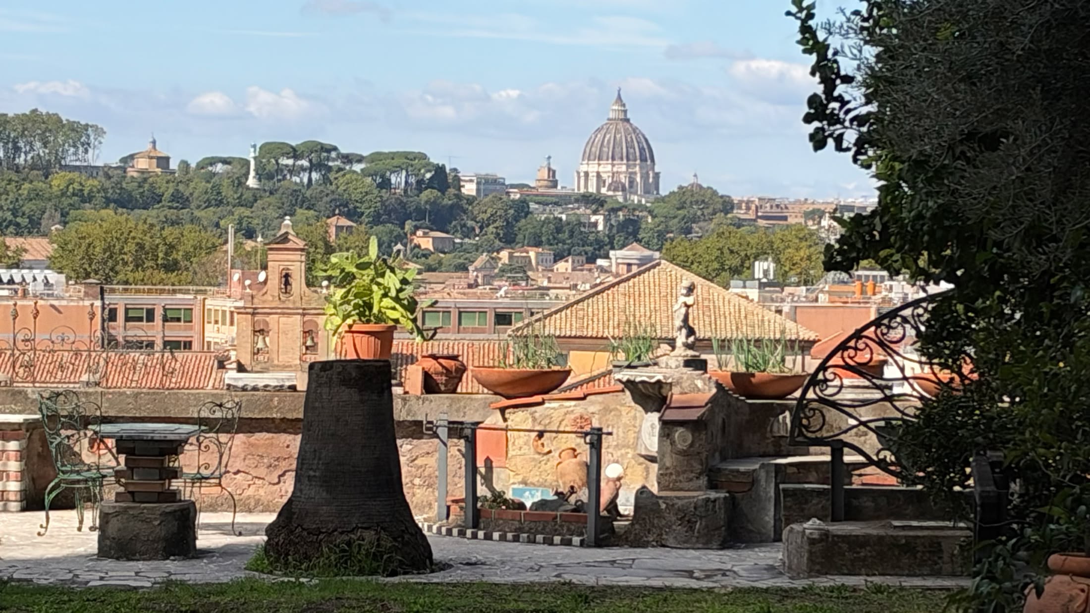 Dal giardino di Sant'Alessio, oltre i vasi e i tavolini di ferro battuto, la cupola di San Pietro.