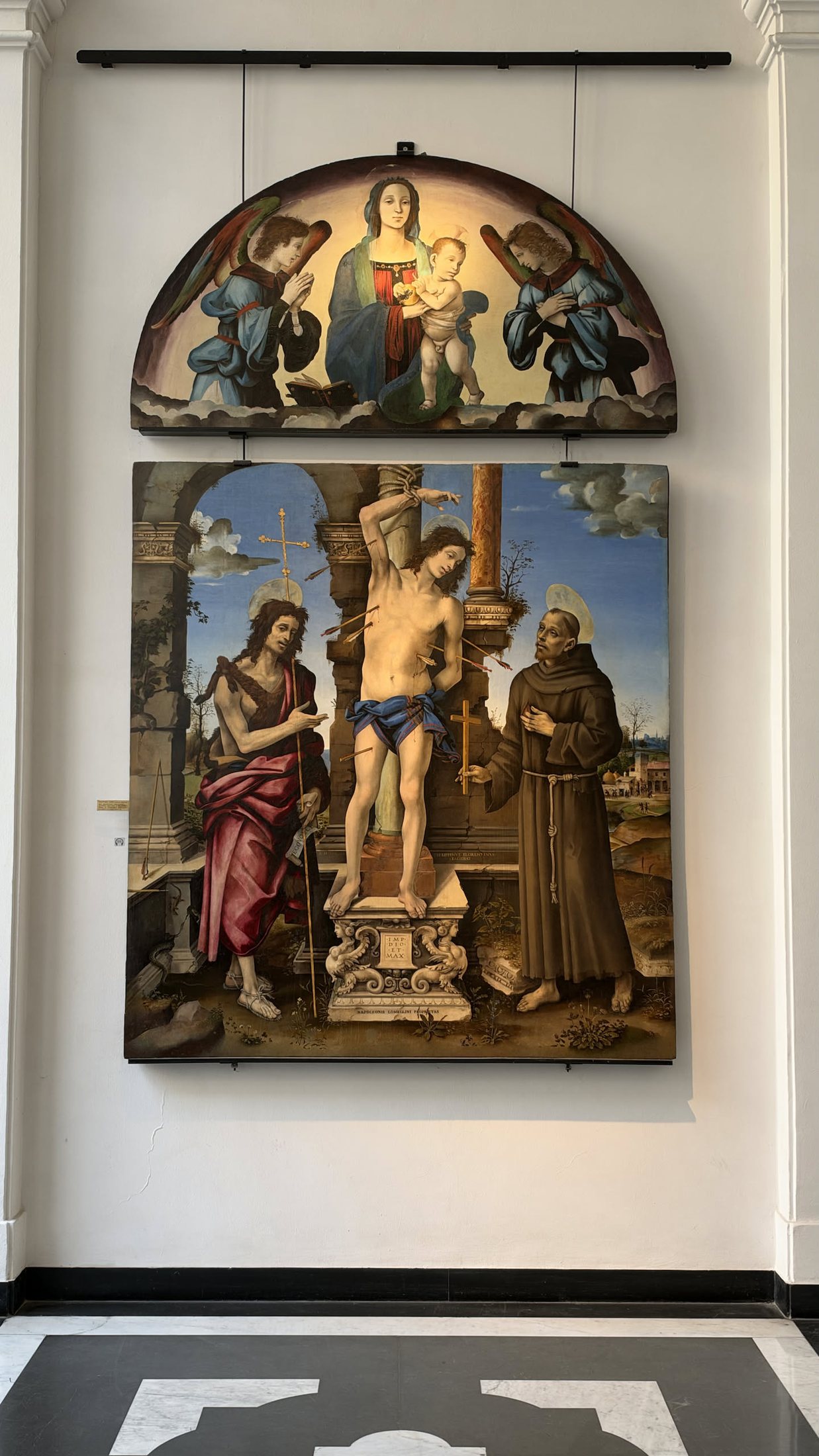 La pala di Filippino Lippi: San Sebastiano fra il Battista e San Francesco, la Madonna nella lunetta.