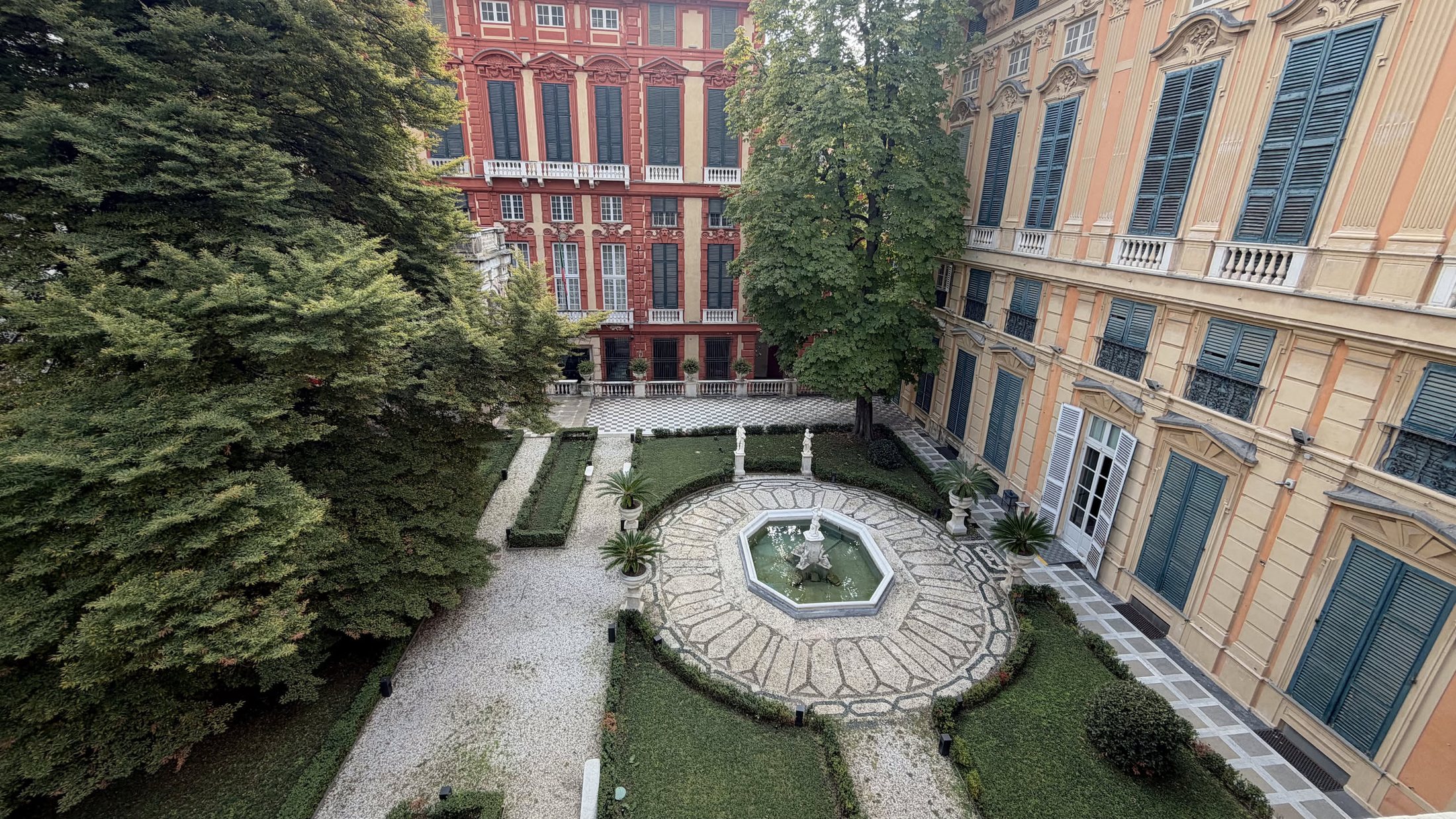 Dalle finestre di Palazzo Bianco, il giardino con la fontana e, oltre gli alberi, la facciata di Palazzo Rosso.