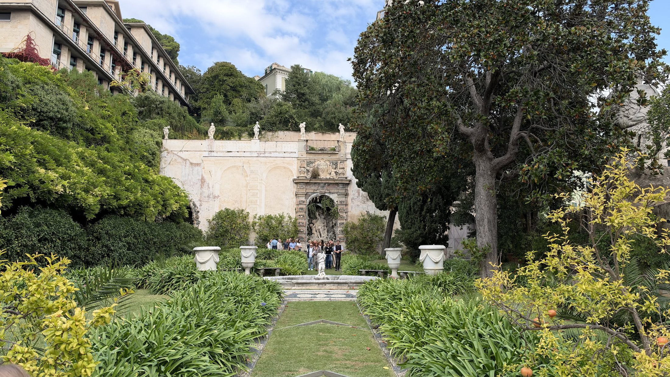 Il giardino pensile all'italiana dietro Palazzo Lomellini, con le aiuole basse e gli alberi grandi.