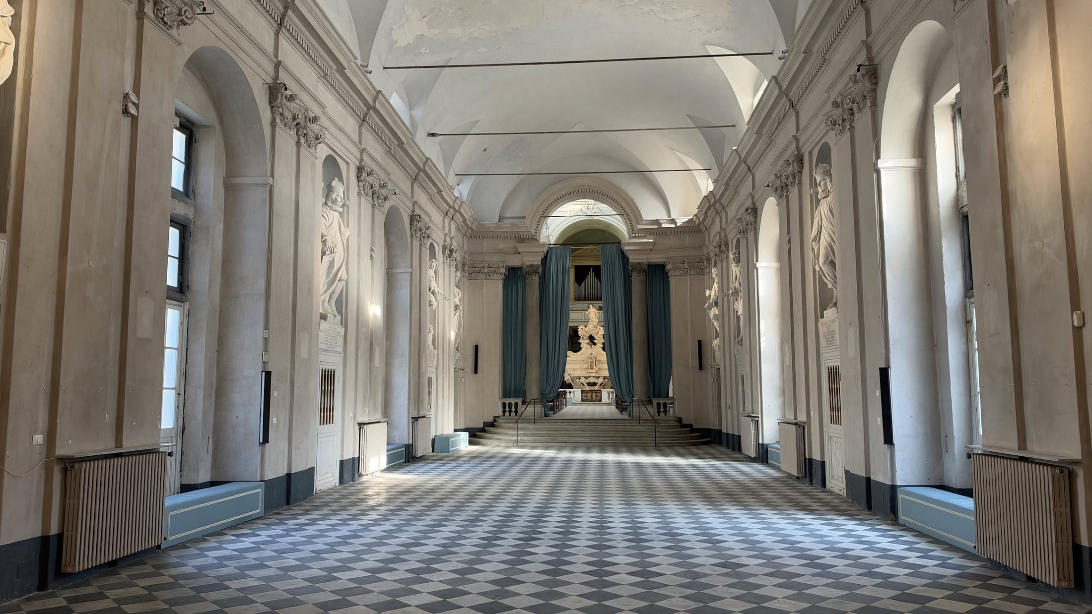 Un'altra galleria, lunga e luminosa, con i suoi scacchi bianchi e grigi.